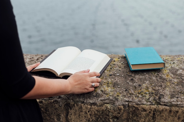 Ragazza che legge un libro in strada