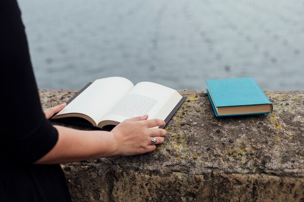 Ragazza che legge un libro in strada