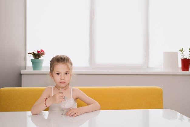 Ragazza che mangia gelato al tavolo