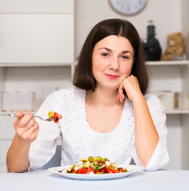 Ragazza che mangia insalata fresca