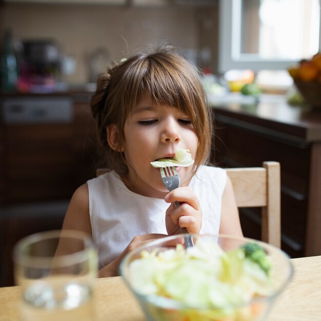 Ragazza che mangia pasto sano a casa