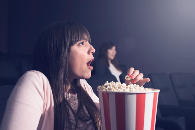 Ragazza che mangia popcorn nel cinema