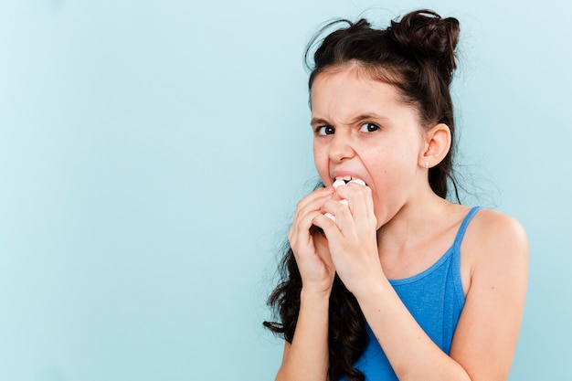 Ragazza che mangia tutto in una volta con copia-spazio