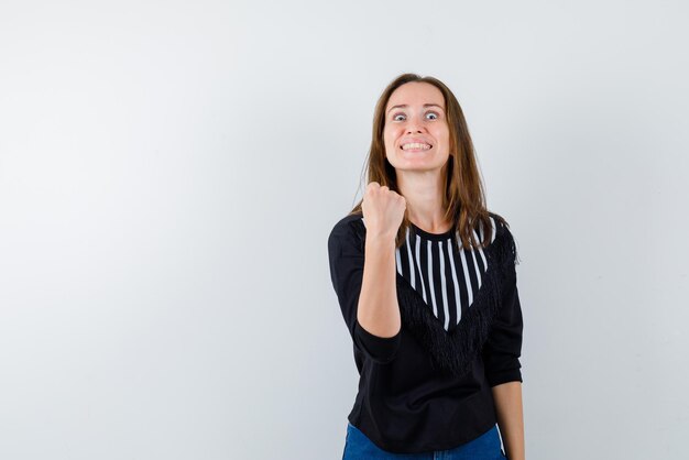 Ragazza che mostra il pugno su sfondo bianco