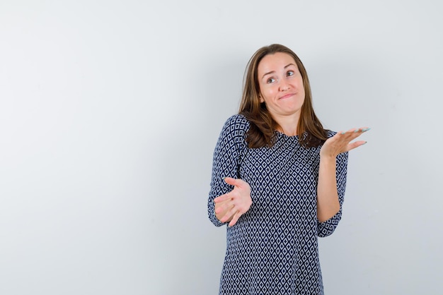 Ragazza che mostra non so il gesto della mano su sfondo bianco