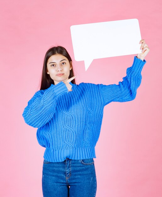 ragazza che mostra segno discorso bolla banner sul rosa.