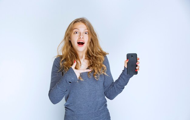 Ragazza che parla al telefono e rimane sorpresa.