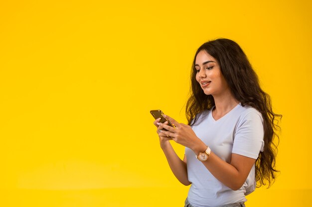 Ragazza che parla e chiacchiera al suo telefono mentre sorride