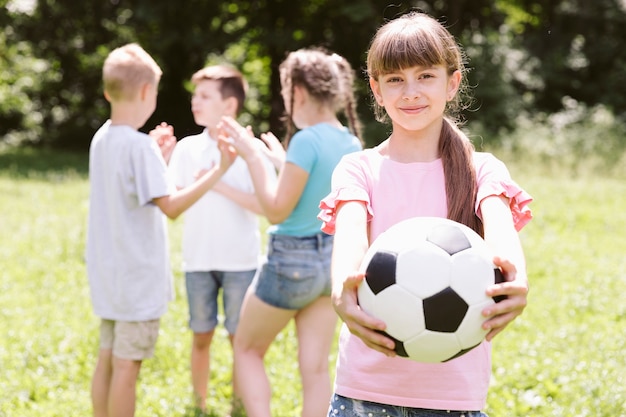 Ragazza che posa con la palla di calcio