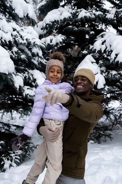 Ragazza che si diverte con suo padre in una giornata invernale nevosa