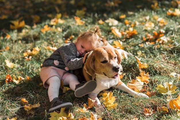 Ragazza che si trova sul suo cane beagle al parco