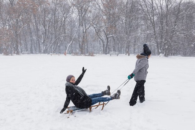 Ragazza che sledding sua madre al winter park