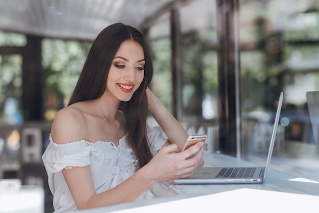 Ragazza che sorride con un computer portatile in una caffetteria