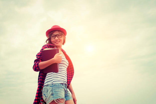 Ragazza che sorride con un libro e cappello rosso