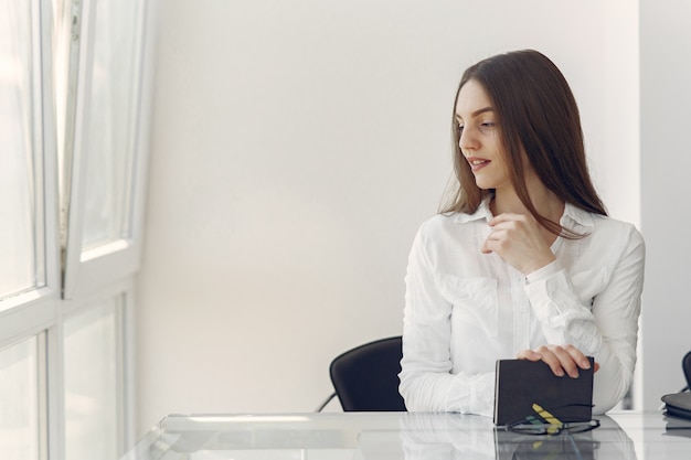 Ragazza che sta nell'ufficio con un taccuino