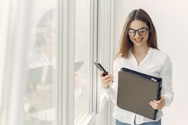 Ragazza che sta nell'ufficio con una cartella