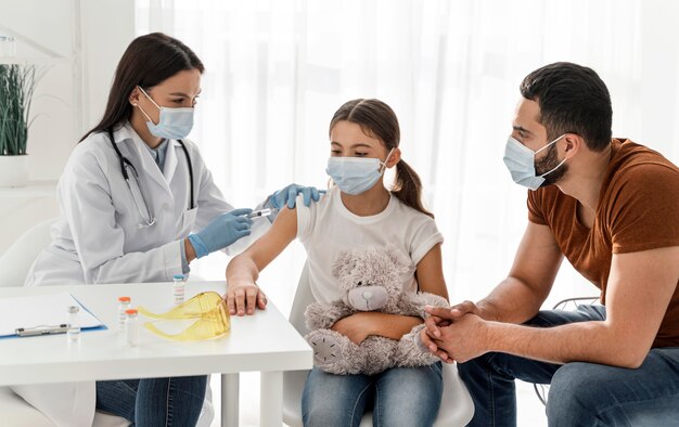 Ragazza che sta vaccinando accanto a suo padre