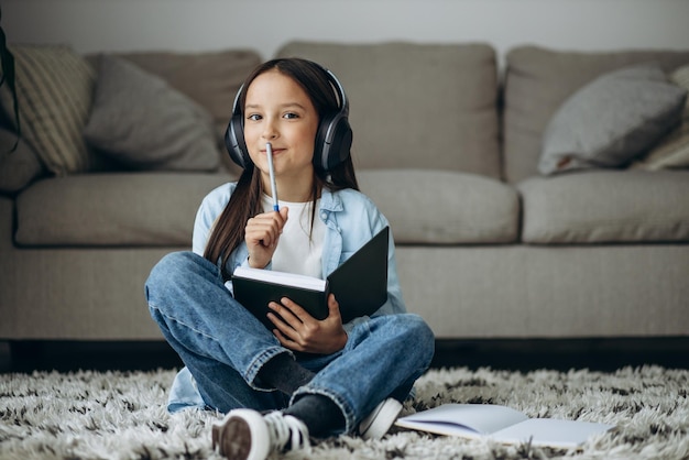 Ragazza che studia a casa e ascolta musica