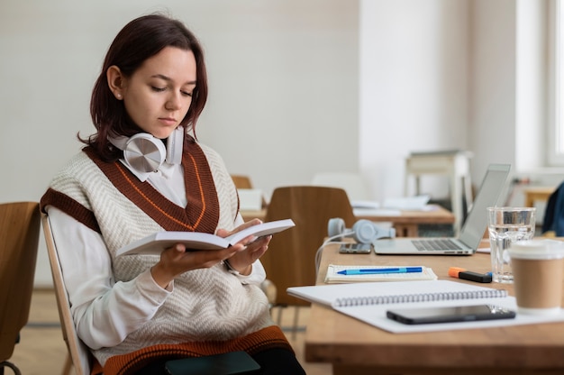 Ragazza che studia da sola sul quaderno durante lo studio di gruppo