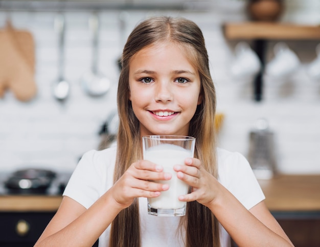 Ragazza che tiene un bicchiere di latte