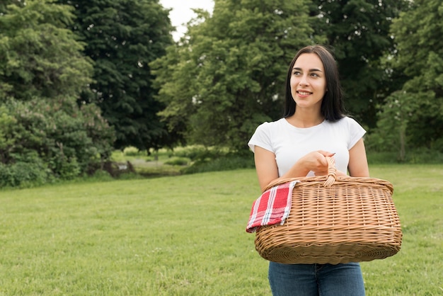 Ragazza che tiene un cestino da picnic