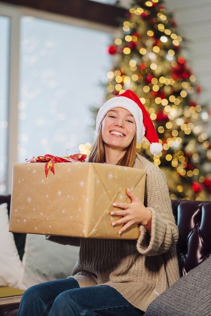 Ragazza che tiene un regalo di Natale la vigilia di Capodanno.