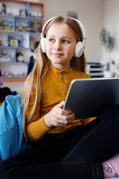 Ragazza che utilizza un tablet per lavorare e ascoltare musica