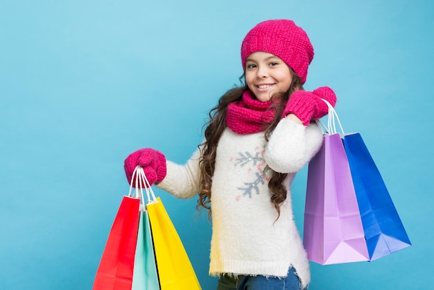 Ragazza con abiti invernali e borse della spesa