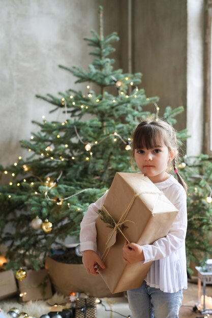 Ragazza con albero di Natale e presente