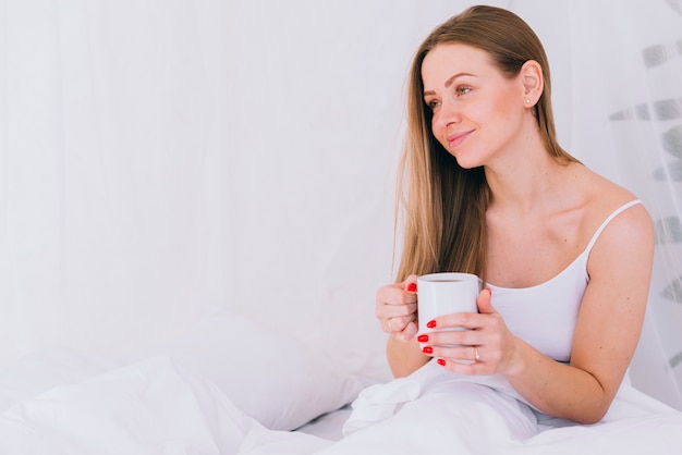 Ragazza con caffè nel letto