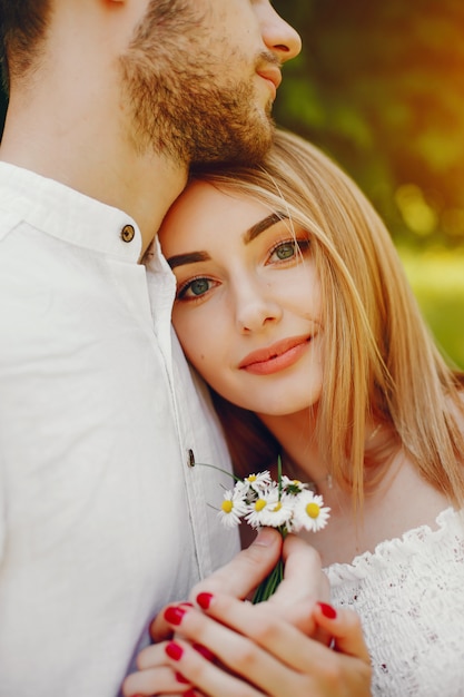 ragazza con capelli chiari e un vestito bianco in una foresta assolato con il suo ragazzo