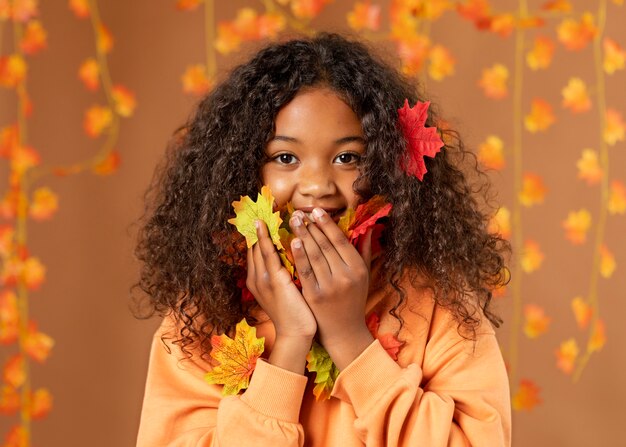 Ragazza con foglie colorate colpo medio