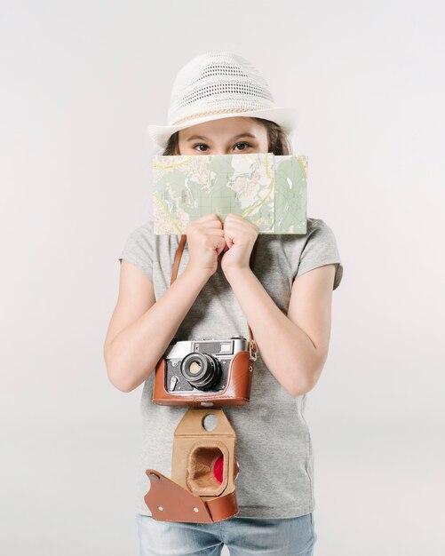 Ragazza con fotocamera e mappa in studio