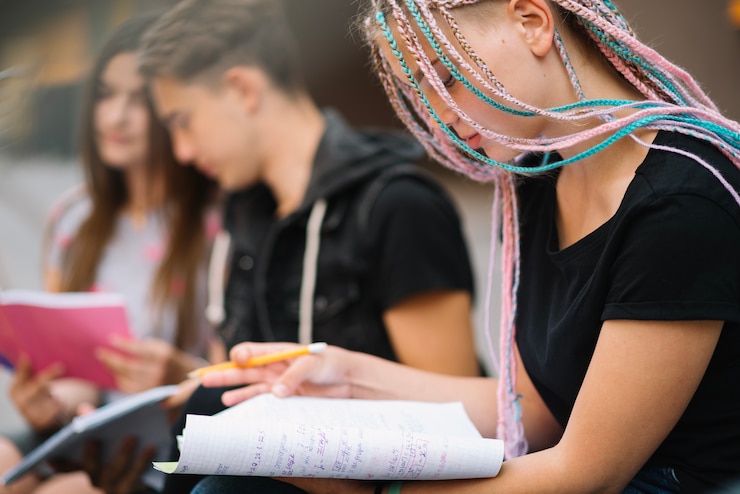 Foto gratuito ragazza con gli amici in posa con i libri