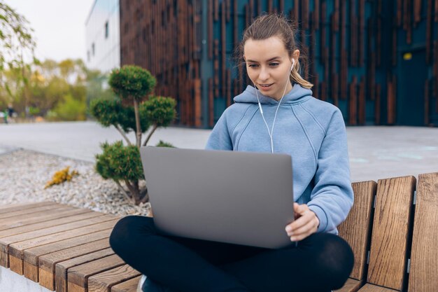 Ragazza con gli auricolari che parla usando la webcam