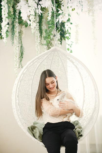 Ragazza con i capelli lunghi. Coniglio bianco tra le braccia della ragazza.