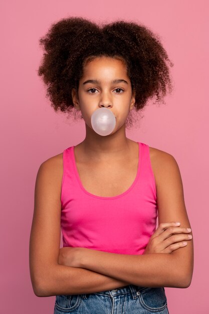 Ragazza con i capelli ricci che fa una gomma da masticare