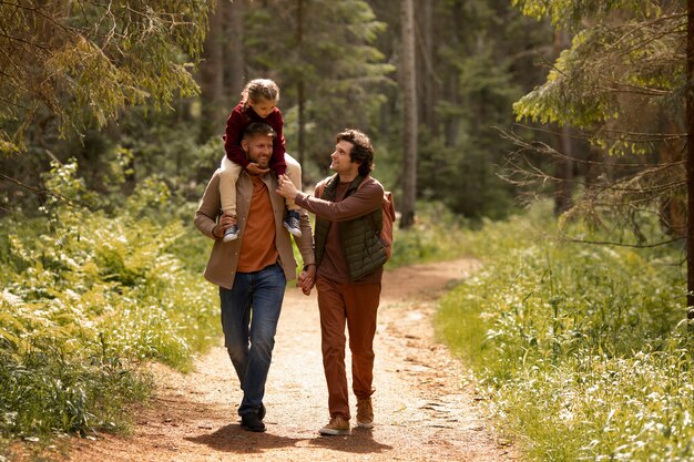 Ragazza con i suoi papà che si gode il viaggio di famiglia