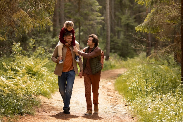 Ragazza con i suoi papà che si gode il viaggio di famiglia