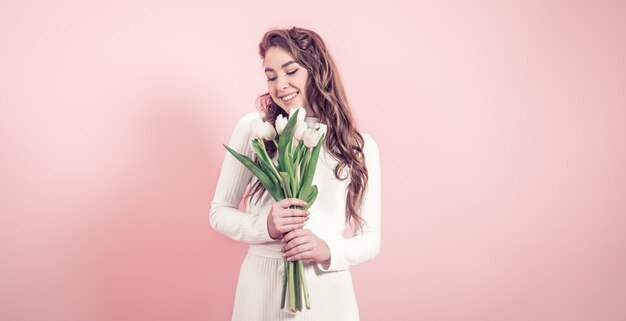 Ragazza con i tulipani su una parete colorata