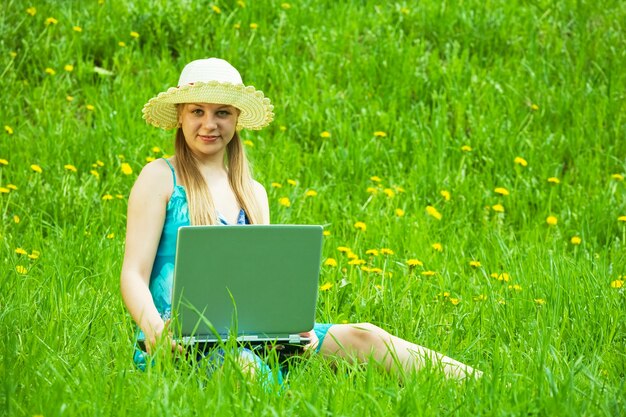 Ragazza con il computer portatile all&#39;aperto