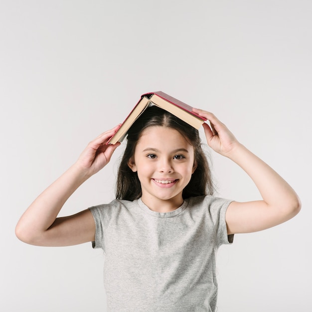 Ragazza con il libro sulla testa in studio