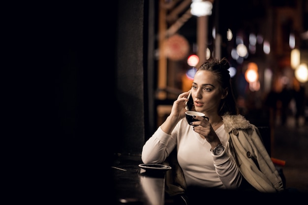 Ragazza con il telefono durante la notte