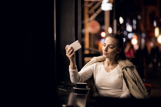 Ragazza con il telefono durante la notte