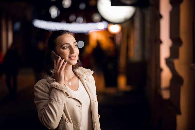 Ragazza con il telefono durante la notte