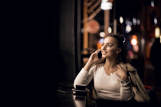 Ragazza con il telefono durante la notte