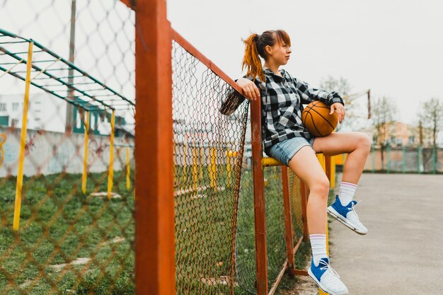 Ragazza con la pallacanestro in ambiente urbano