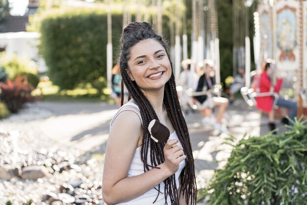 Ragazza con la scatola acconciatura treccia in possesso di un gelato