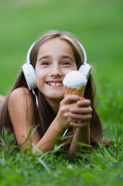 Ragazza con le cuffie che mangia il gelato