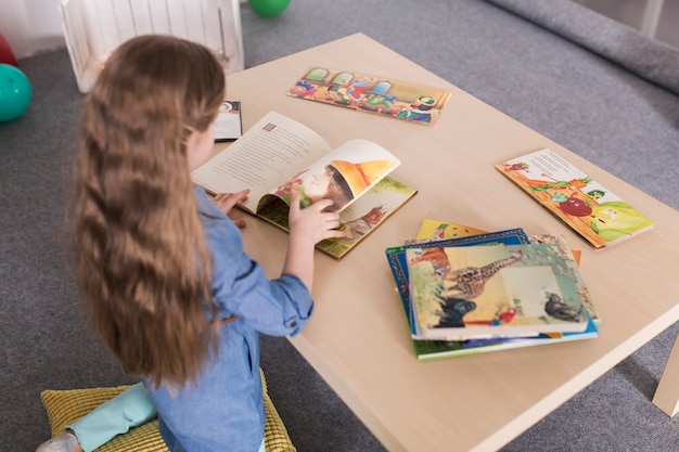 Ragazza con libri sul tavolo